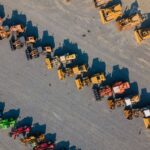 Aerial view of perfect rows of wheel loaders and other heavy machinery